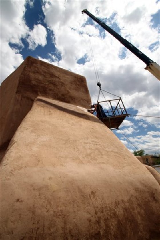 Parishioners of San Francisco de Asis Church in Ranchos de Taos, N.M., apply mud to the thick adobe walls of the church as part of an annual ritual that has been done for nearly 200 years.